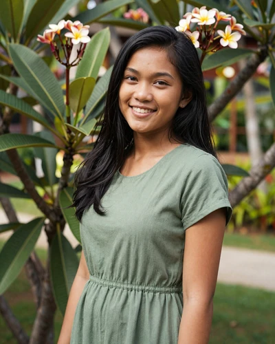 Indonesian woman Dewi from Bali in a green dress in a tropical garden