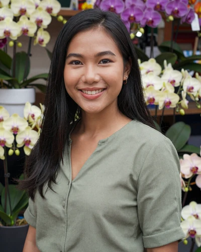 Thai woman Noi from Chiang Mai smiling near a colorful flower market