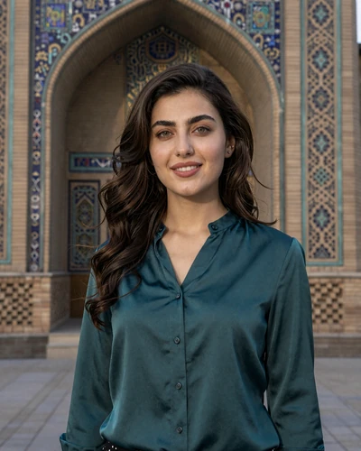 Uzbek woman Nodira from Tashkent in a teal silk blouse near ornate tilework