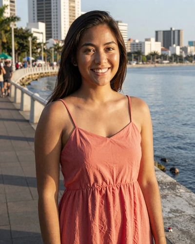 Filipina woman Dara from Manila in a coral sundress on a sunny waterfront